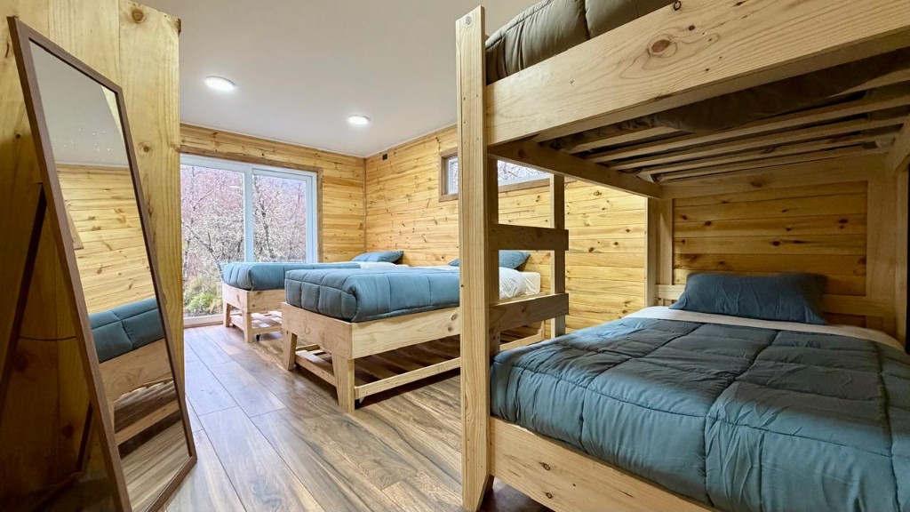 Habitación de Refugio Kürü con literas de ropa de cama azul y camas individuales
