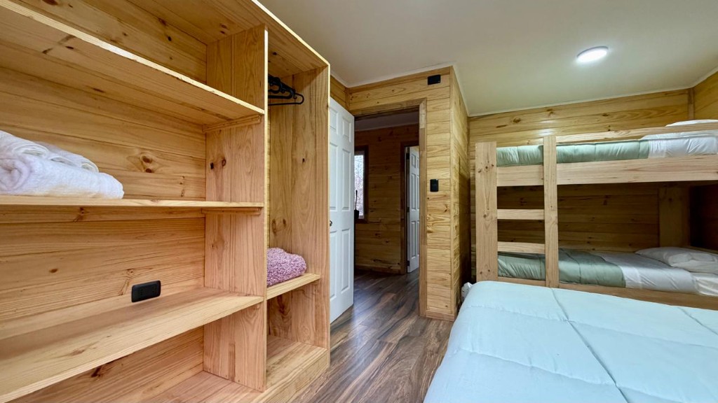 Habitación de Refugio Kürü con clóset de madera, literas y cama