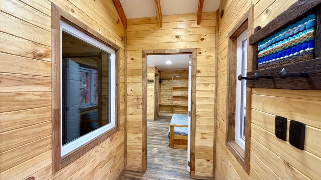Acceso al dormitorio principal de Refugio Kürü desde el pasillo de madera